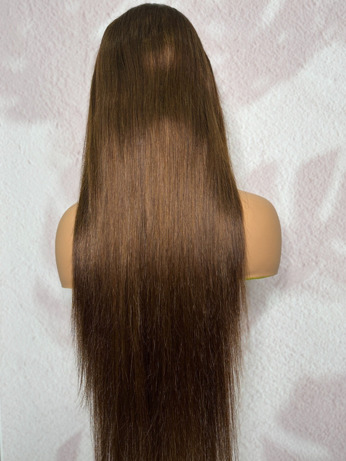 Mannequin head with long brown hair on a white background